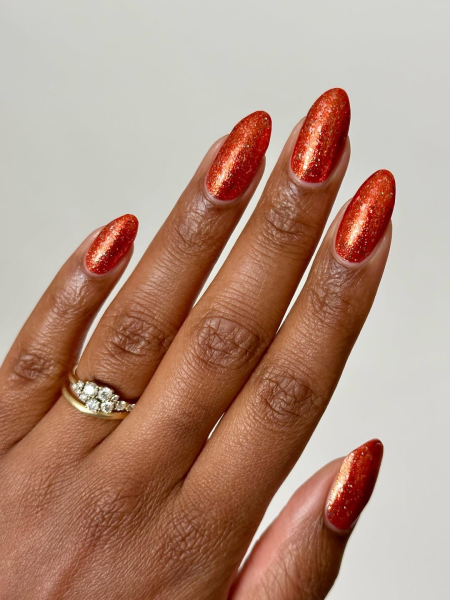 Copper orange nails on brown hand